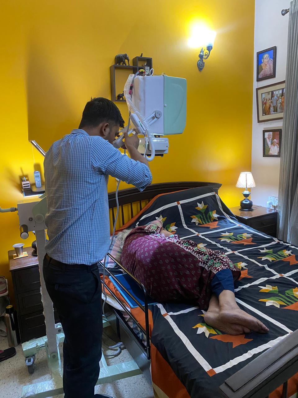 Xtra Xray technician operating the portable X-ray unit over a patient at home