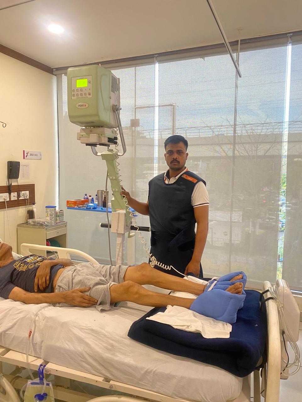 Radiographer in lead apron operating the Allenger Port-X portable unit
